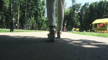 yüksek topuklar üzerinde zarif kadın parkta yürüyor