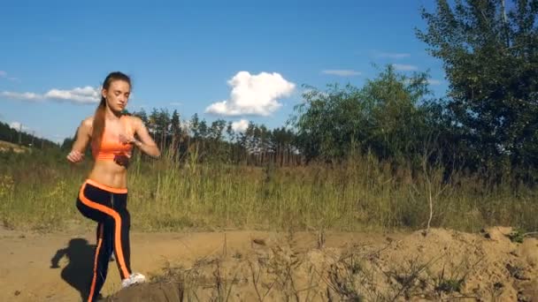 Young slim blonde makes sport exercices on a sand — Stock Video