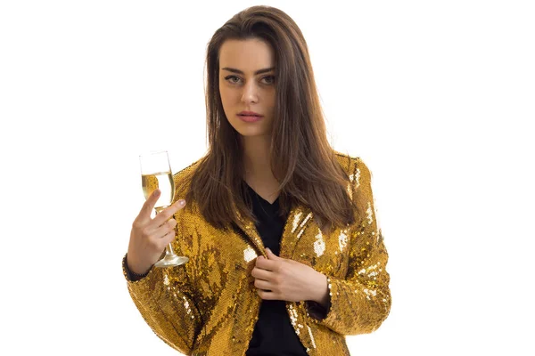 Σοβαρή κοπέλα σε Χρυσή σακάκι με ποτήρι κρασί στα χέρια εξετάζει τη φωτογραφική μηχανή — Φωτογραφία Αρχείου