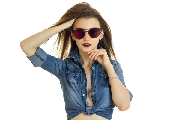 Hot lady in jeans jacket without bra looks at the camera in sunglasses — Stock Photo, Image