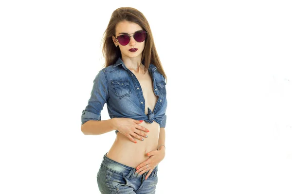 Mulher atraente em roupas de jeans casuais e óculos de sol posando na câmera — Fotografia de Stock
