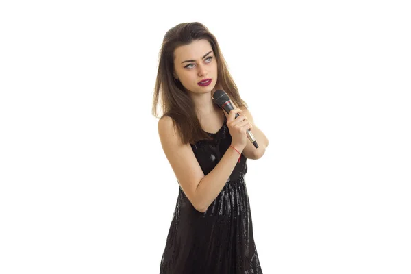 Woman in black dress with microphone in hands singing — Stock Photo, Image