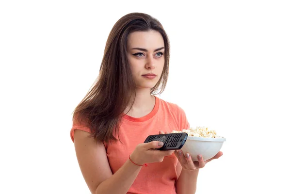 Женщина с пультом и поп-корном смотрит телевизор — стоковое фото