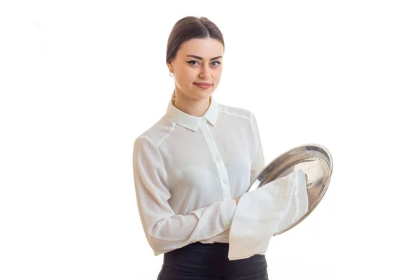 Красивая молодая официантка чистит серебристый Трей и смотрит в камеру — стоковое фото