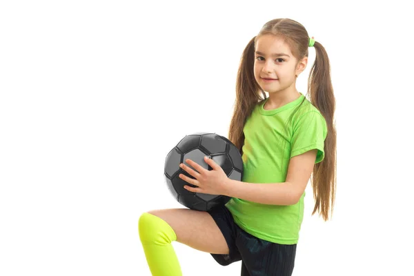 Kleines Mädchen mit Frack in grünem T-Shirt mit Ball — Stockfoto