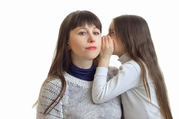 Маленька дівчинка щось каже своїм матерям вухо крупним планом — стокове фото