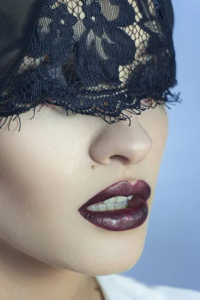 Gros plan de jeune femme sensuelle avec de belles lèvres violettes et de la dentelle sur les yeux — Photo