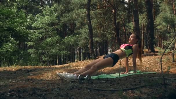 La ragazza d'idoneità atletica in piumaggio lucente sta in un'assicella su mani — Video Stock