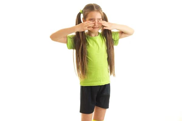 小女孩在绿色体育统一隐藏她的眼睛与手 — 图库照片