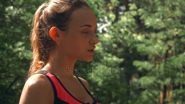 젊은 뜨거운 스포츠 여자 숲에 젖은 얼굴로 서 고 뺨 아래로 흐름 — 비디오