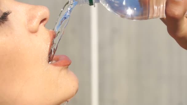 Chica vierte agua de una botella en la cara — Vídeos de Stock