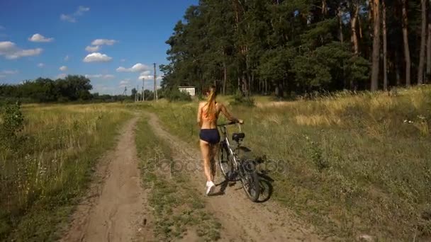 Mujer joven con una bicicleta — Vídeo de stock