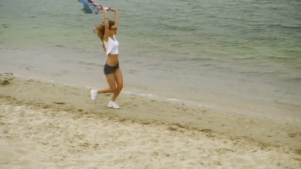 Bonito jovem loira corre em uma praia — Vídeo de Stock
