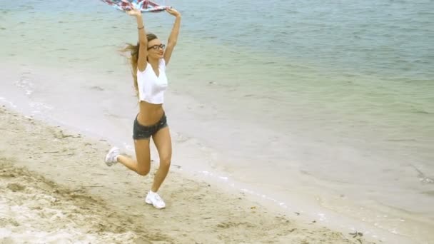 Bonita rubia corre en una orilla del mar — Vídeo de stock