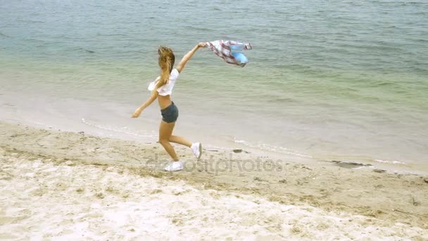 Cutie loira corre em uma praia — Vídeo de Stock