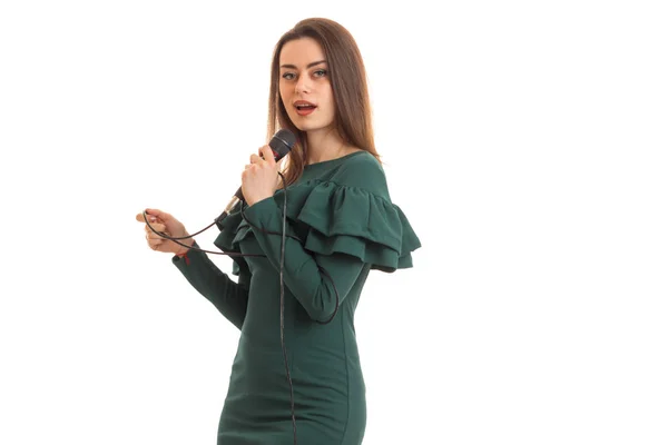 Красивая молодая девушка в платье поет в микрофон — стоковое фото