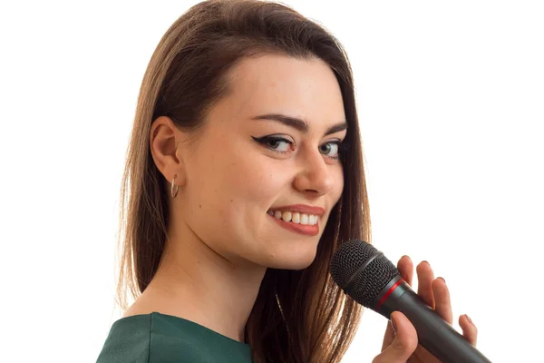 Retrato de cerca de una joven notable que está sonriendo y sosteniendo un micrófono —  Fotos de Stock