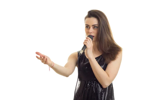 Hübsches junges Mädchen in schwarzem Kleid, das Karaoke singt — Stockfoto