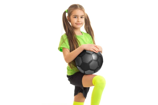 Schattig klein meisje in de groene shirt met voetbal in handen — Stockfoto