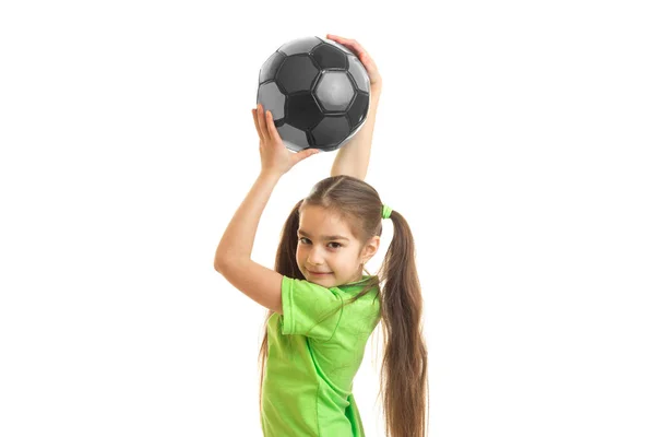 Porträt eines kleinen Mädchens, das über dem Kopf des Fußballballs angehoben wird — Stockfoto