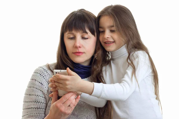 En närbild porträtt av unga mammor och döttrar som ser i telefon — Stockfoto