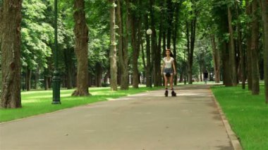 sıska kadın şort bir parkta silindirler üzerinde sürme