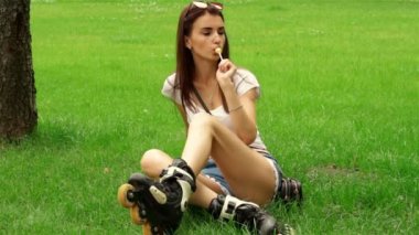 güzel kız Silindirler'ın bahçesinde oturur ve lolipop berbat