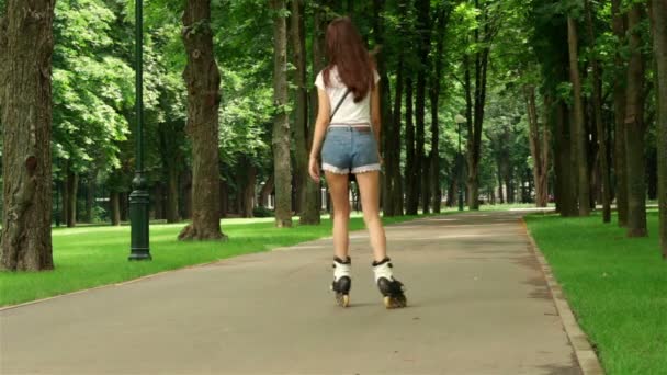 Slank jong meisje in broek skaten — Stockvideo
