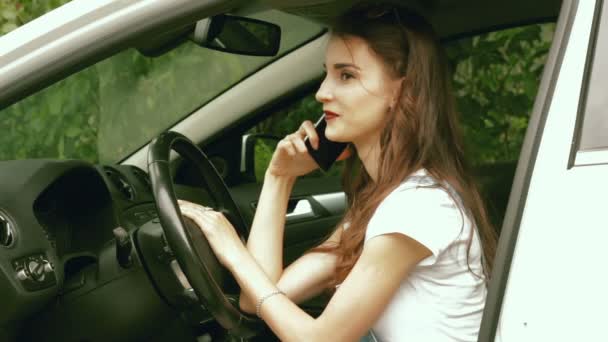 Glamour dame zittend in de auto tijdens het rijden en praten over de telefoon — Stockvideo