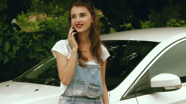 Menina bonita de pé perto do carro e disse pelo telefone móvel — Vídeo de Stock