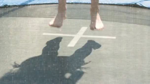 En ung flicka som hoppar på en studsmatta i sommar — Stockvideo
