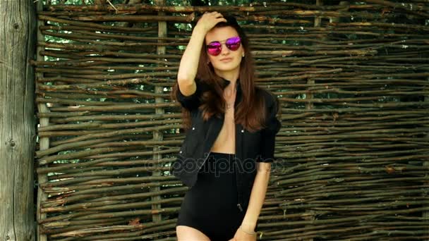 Glamour menina sexy em óculos e poses roupas pretas — Vídeo de Stock