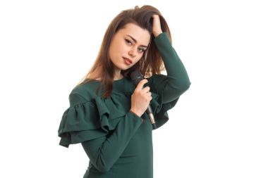 elinde bir mikrofon ile çekici genç şarkıcı saç artırır ve bir kameraya benziyor