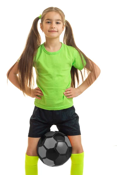Dikey portre spor bacaklar arasında topu tutan küçük kız — Stok fotoğraf