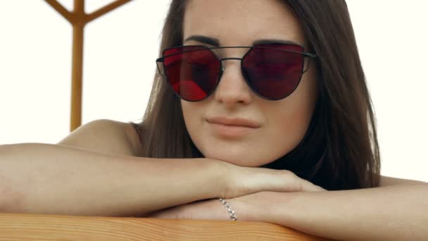 Glamorösa flicka i ljusa glasögon brun på stranden — Stockvideo