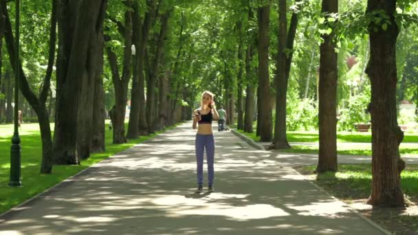 Unga fitness flicka i byxor löper genom parken — Stockvideo