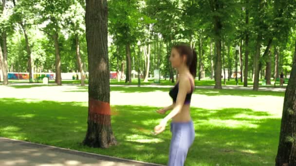 Brunett tonåring hoppar rep i parken — Stockvideo