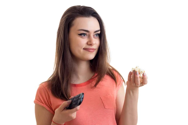 Ganska ung kvinna tittar på en tv med pop-corn — Stockfoto
