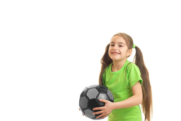 Lächelndes kleines Mädchen steht im Studio und hält den Ball — Stockfoto