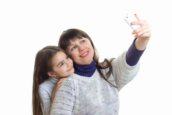 Jovem mãe sorri e faz a foto no telefone com sua filha — Fotografia de Stock