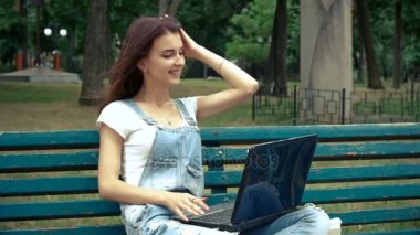 güzel genç kız bir dizüstü bilgisayarda iletişim kurar.