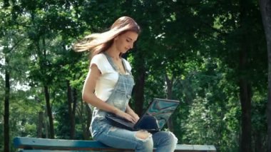 sevimli genç esmer oturur ve dizüstü bilgisayarınızda yazdırır