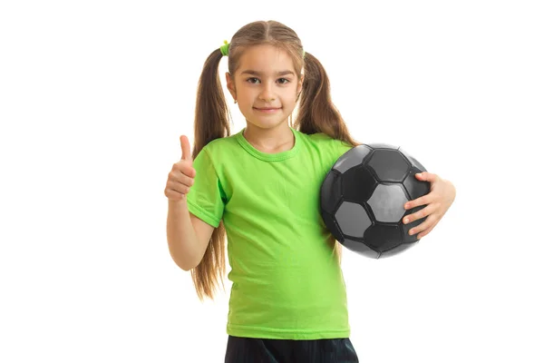 Little girl with soccer ball in hands looking at the camera showing thumbs up — Stock Photo, Image