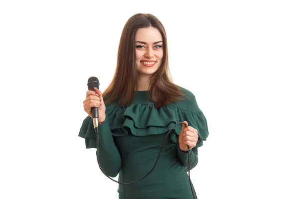 Glad tjej med mikrofon i grön klänning — Stockfoto
