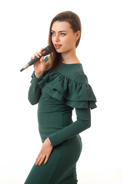 Γοητευτικό κορίτσι με μικρόφωνο σε ένα πράσινο φόρεμα — Φωτογραφία Αρχείου