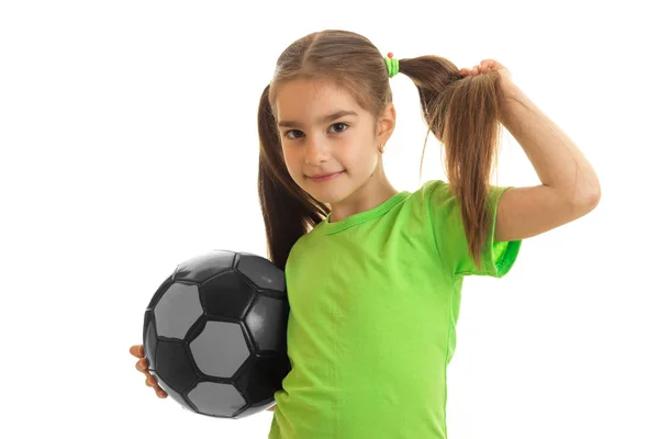 Portret van een jong meisje in de groene shirt met voetbal in handen — Stockfoto