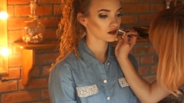 makyaj sanatçısı dudaklarını güzel bir genç kız boyar.
