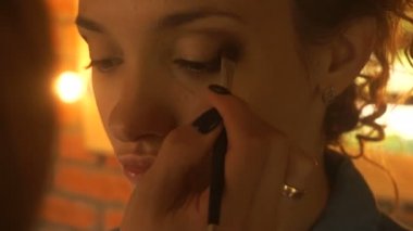 makyaj sanatçısı fırça göz gölgeler ile bir kadın boyar.