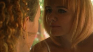 Kadınlar makyaj sanatçısı bir kıza bakar ve makyaj yapar