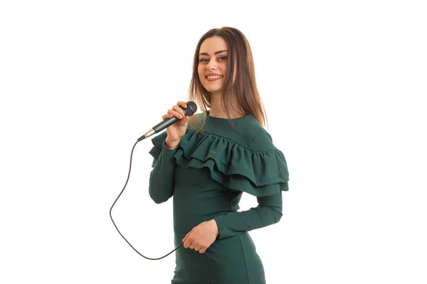 Mujer alegre en vestido de color verde con micrófono en las manos —  Fotos de Stock